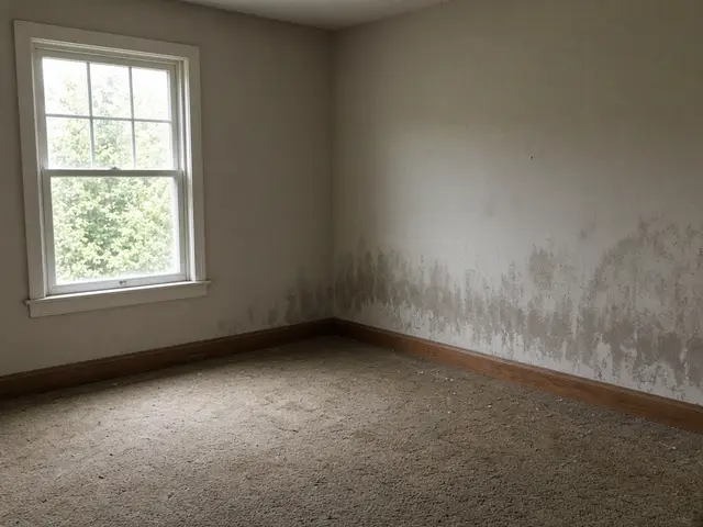 Room corner with light soot staining above the baseboard